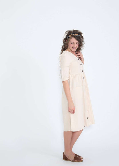 Modest women's cream cotton dress with brown buttons and half sleeves