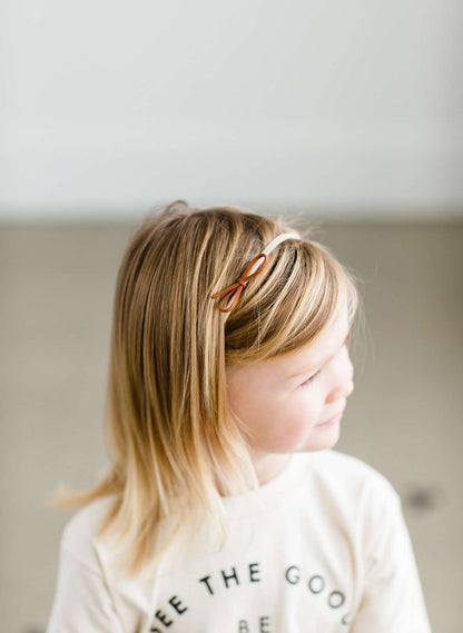 Young girls small leather bows headbands, this comes as a set of three on a nylon band.