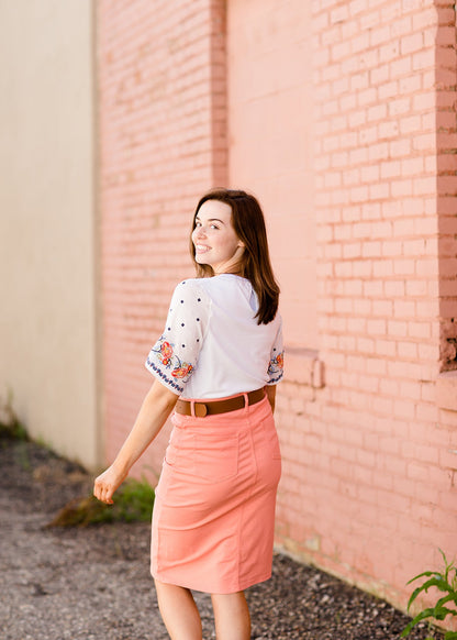 White top with multi color floral embroidered knit sleeves