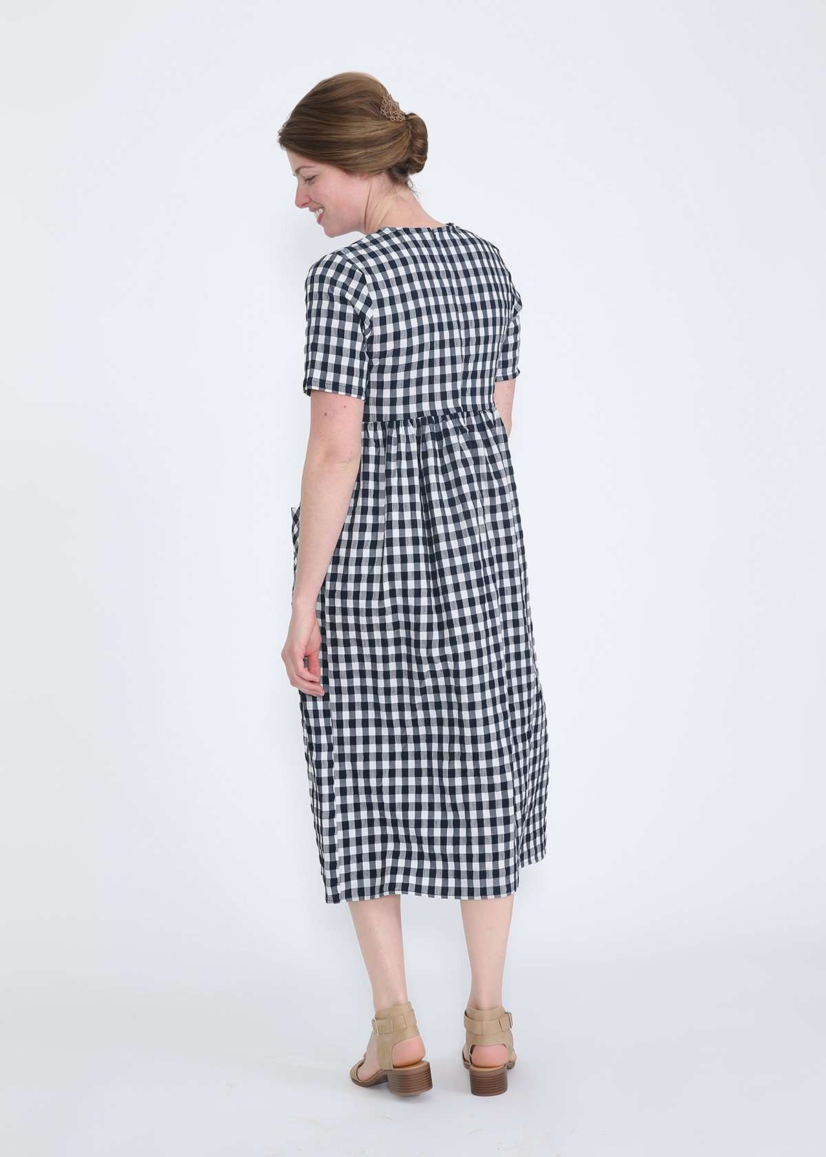 woman wearing a navy and white gingham print midi dress