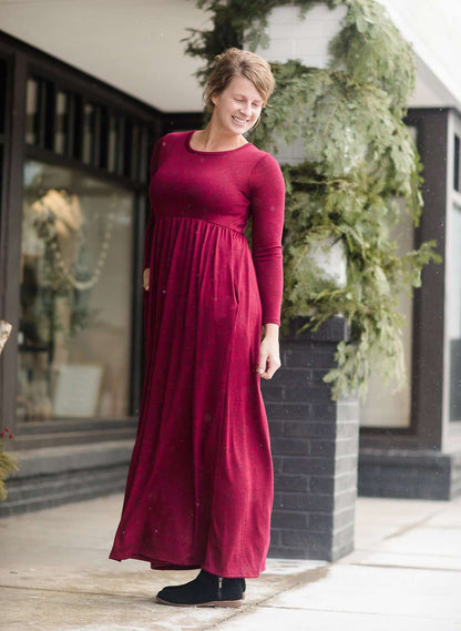 Woman wearing a wine colored maxi dress made of a hacci material standing outside of Inherit Clothing Company