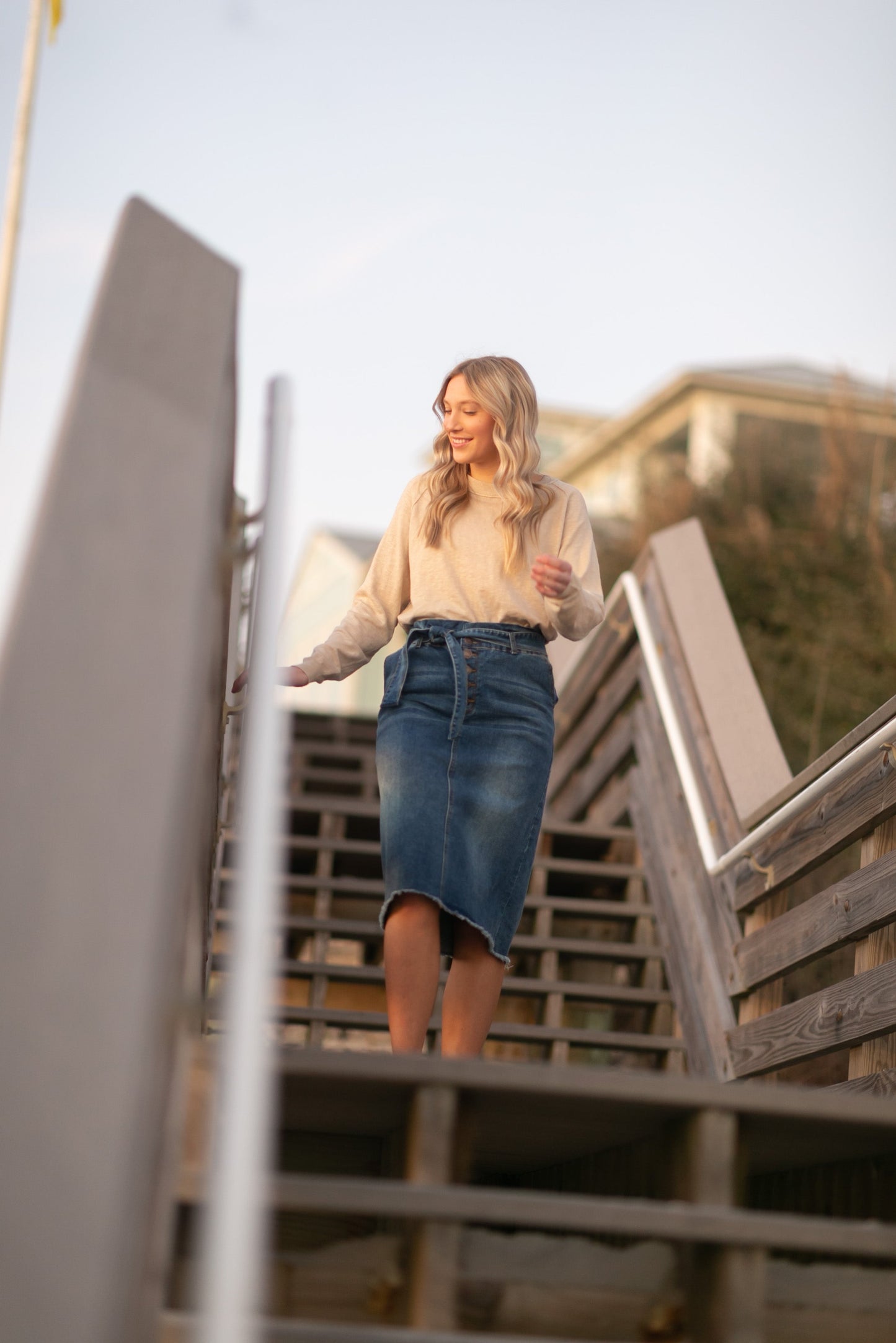 This midi length skirt is made out of stretch denim, with a paperbag stretch waist, with a matching belt, and a raw hem.